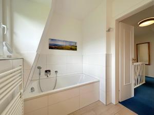 Koupelna v ubytování Endreihenhaus in Keitum mit Badewanne und Grossem Garten