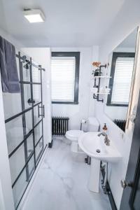 a white bathroom with a sink and a toilet at Centrally located East End & off-street parking in Portland