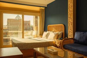 a room with a bed and a couch and a window at Jimmy Pyramids Hotel in Cairo