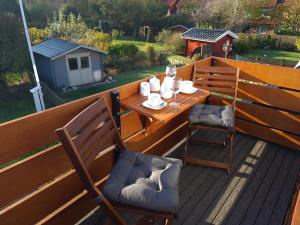 une table en bois et deux chaises sur une terrasse dans l'établissement Ferienwohnung in Tinnum mit Balkon, à Tinnum