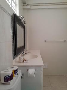 een witte badkamer met een wastafel en een spiegel bij Melrose Beach Apartments Inc in Bridgetown +9 foto's