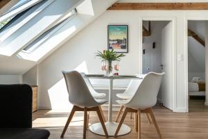 Un comedor con una mesa y sillas blancas. en LOGODEN - Appartement TOUT CONFORT 2 Chambres, proximité gare, parking privé, en Vannes
