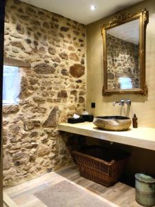 a stone bathroom with a sink and a mirror at La Terrade in Saint-Hilaire-La-Treille