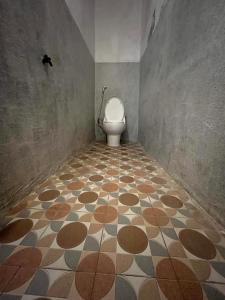 a bathroom with a toilet and a tiled floor at Signature Scuba Gili Gede Dive and Stay in Gili Gede