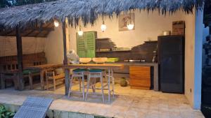 une cuisine avec une table, des chaises et un réfrigérateur dans l'établissement Villa Subak 3 bed room, à Ubud