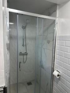 a shower with a glass door in a bathroom at Watford Junction, King Size Bed in Watford +8 photos