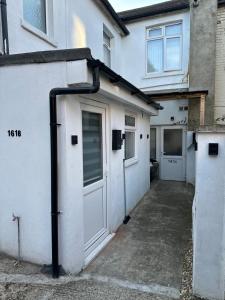 un bâtiment blanc avec une porte et un garage dans l'établissement Watford Junction, King Size Bed, à Watford