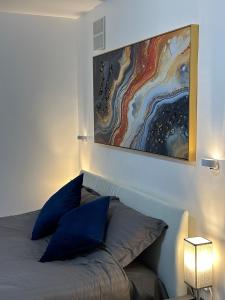 - une chambre avec un lit doté d'oreillers bleus et d'un tableau dans l'établissement Watford Junction, King Size Bed, à Watford 8 autres photos