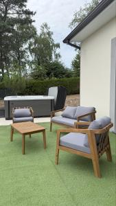 un patio avec deux chaises, une table et un banc dans l'établissement Maison avec Jacuzzi proche du lac, à Marcillac-la-Croisille