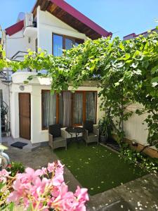 a garden with two chairs and a table in front of a house at Casa Eladi in Eforie Sud
