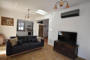 a living room with a couch and a flat screen tv at Sofia Villa Near Faliraki in Kalithies