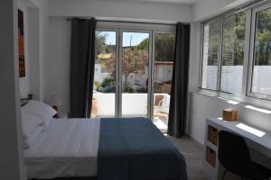 a bedroom with a bed and a view of a patio at Sofia Villa Near Faliraki in Kalithies +23 photos