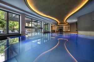 a swimming pool with blue tiles in a building at Hotel Kendler in Saalbach-Hinterglemm