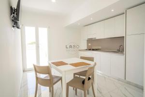 a white kitchen with a white table and chairs at Residenza Gabbaturco Green Stay Mare e Aeroporto Senza Auto in Santa Domenica