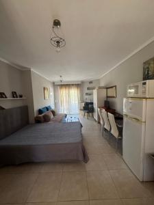 a bedroom with a bed and a desk and a refrigerator at Roses Apartments in Nea Michaniona