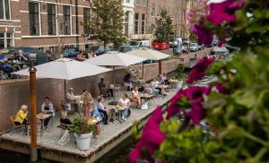 a group of people sitting at tables with umbrellas at B&B De Amsterdamse Poort in Haarlem