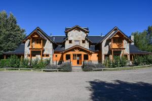 a large wooden house with a black roof at Sieteflores Hosteria De Montaña in San Martín de los Andes