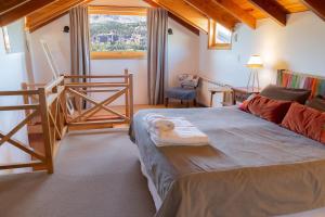 a bedroom with a large bed and a staircase at Sieteflores Hosteria De Montaña in San Martín de los Andes +96 photos