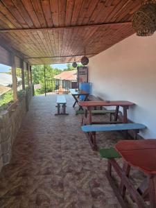 a patio with picnic tables and benches in a building at casa la meduza in Vama Veche