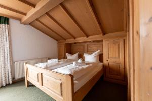 a large bed in a room with a wooden ceiling at Ferienwohnungen Chiemgau in Rottau