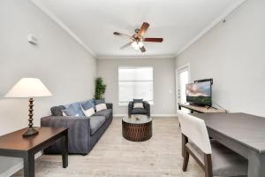 马格诺利亚Modern 1BR Retreat Open Layout, Workspace, Views的带沙发和吊扇的客厅