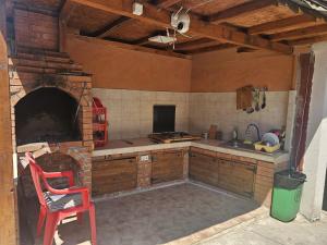 a kitchen with a brick oven and a red chair at casa la meduza in Vama Veche