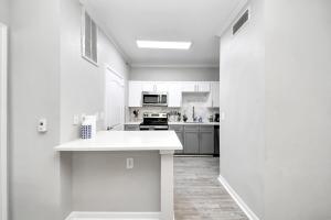 马格诺利亚Modern 1BR Retreat Open Layout, Workspace, Views的厨房配有白色橱柜和白色台面