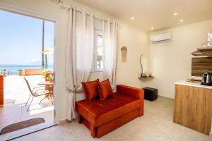 a living room with a red chair and a balcony at WaterSide Studios in Limenaria