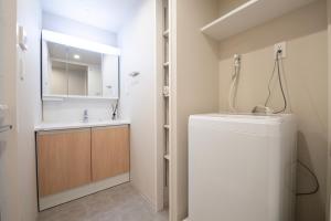 a bathroom with a sink and a toilet and a mirror at THE RISE Osaka Universal Bayside in Osaka