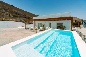 a swimming pool in front of a house at Luxury House La Maison in Tías