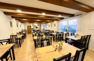 a dining room with wooden tables and chairs at Penzión Pavčina Lehota in Pavčina Lehota