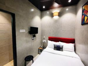 a bedroom with a white bed and a red headboard at Hotel Eros - Nr Airport T2 in Mumbai