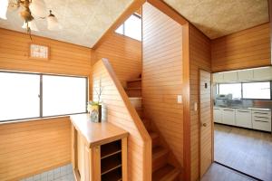 a room with wooden walls and a staircase in a house at 海の小石 in Ito