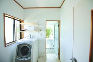 a bathroom with a washing machine and a shower at 海の小石 in Ito
