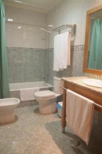 a bathroom with a toilet and a sink and a tub at Hotel Portas Do Dao in Penalva do Castelo +4 photos