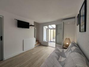 TV a/nebo společenská místnost v ubytování Villa T3 rénovée climatisée, piscine, proche plage et commerces - FR-1-81-622