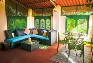 a living room with a blue couch and a table at Shantidarshan Homestay in  Amboli 