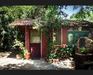 a red house with a red door and some plants at Shantidarshan Homestay in  Amboli  +16 photos