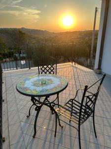 a table and two chairs on a patio with the sunset at Dimora i Mandorli 1 in Colonnella