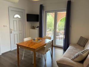 a living room with a wooden table and a couch at Natasa apartments Krk in Vrh