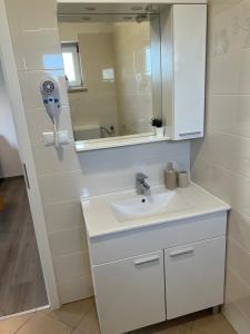 a bathroom with a white sink and a mirror at Natasa apartments Krk in Vrh +30 photos