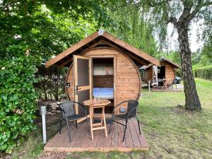 a small wooden cabin with two chairs and a table at Schlaffass Bibi in Dörverden