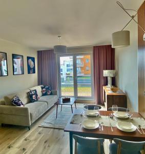 a living room with a couch and a table at Apartament Gruszowe Sady Nowaka 6 in Olsztyn +11 photos