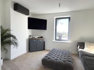 Una sala de estar con un sofá y un televisor de pantalla plana. en 7 Bays House, en Moffat 6 fotos más