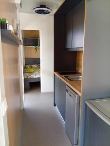 a small kitchen with a sink and a bed at Ancarano mobile house & whirlpool in Ankaran +13 photos