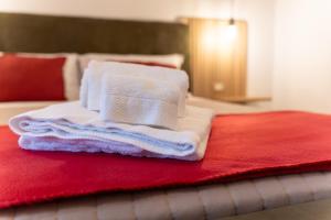a pile of towels sitting on top of a bed at Domus Juvenilia in Noto