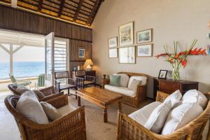 a living room with wicker chairs and a table at La Plage I Beachfront Villa on the Lagoon in Centre de Flacq