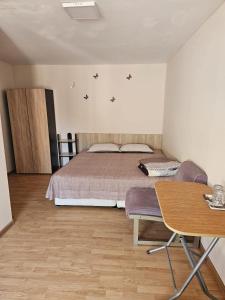 a bedroom with a bed and a table and a desk at casa la meduza in Vama Veche