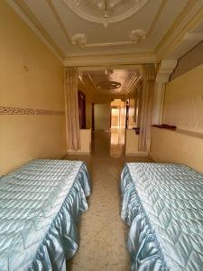 two beds sitting next to each other in a room at شقة للكراء بشاطئ زمانة بالجبهة in El Jebha