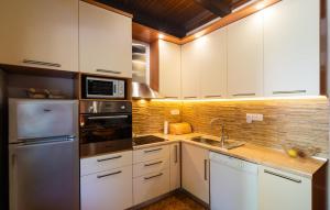 Una cocina con gabinetes blancos y electrodomésticos de acero inoxidable. en Lovely Home In Hvar With Wifi, en Hvar